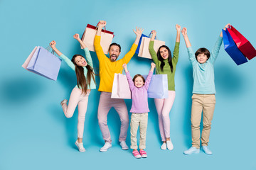 Full length body size view of nice attractive glad cheerful big full family carrying bag new thing clothes clothing boutique rising hand up isolated on bright vivid shine vibrant blue color background