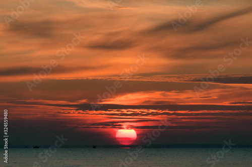 Paysage de coucher de soleil en bord de mer et nuages colorés oranges avec place pour écriture