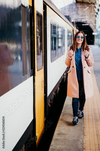 happy young woman walking at train station. Travel concept