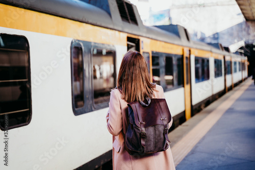 happy young woman walking at train station. Travel concept photo