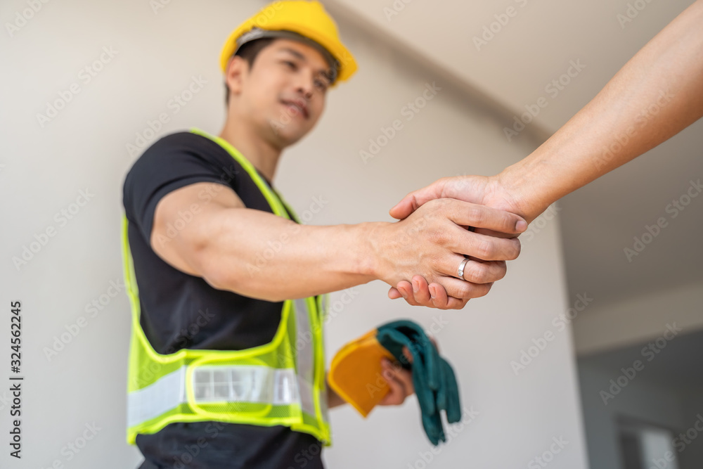 Engineers in protective helmets and vests are shaking hands while working in successful projects, Unity and teamwork concept.. Engineers in protective helmets and vests are shaking hands while working in successful projects, Unity and teamwork concept..