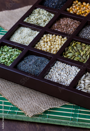 A close up of a wooden box filled with compartments of seeds and grains. © Carey
