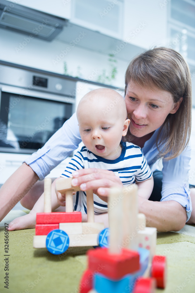Happy mother playing with her baby at home Happy mother playing with her baby at home