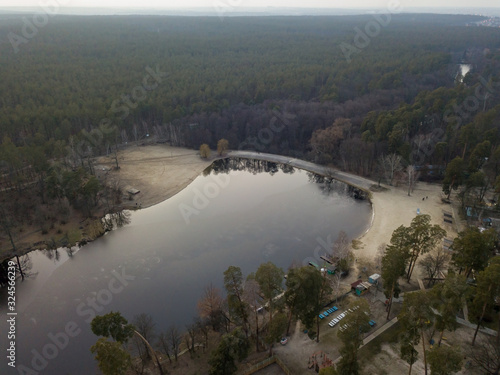 Aerial drone view. Lake in a coniferous forest at dusk.