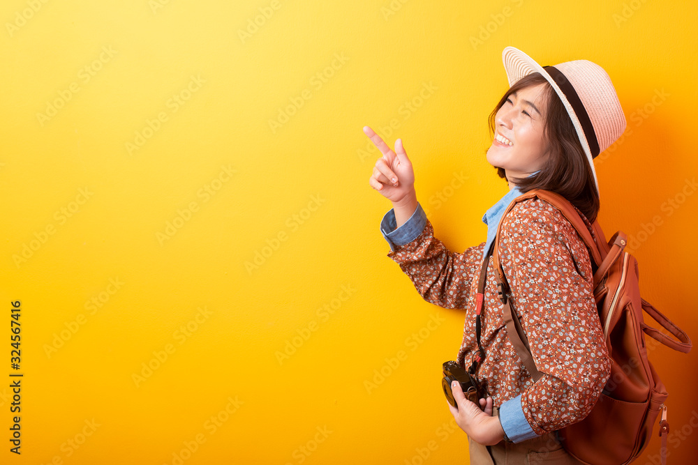 Happy Young Asian tourist woman on yellow background Happy Young Asian tourist woman on yellow background