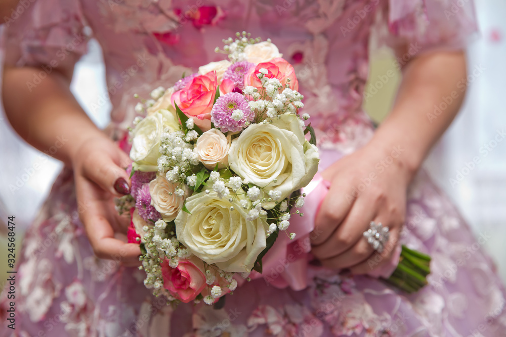 Bride and groom hands with wedding white flowers and pink bridal dress . Bride and groom's hands with wedding flowers . Wedding couple holding hands . Bride and groom hands with wedding white flowers and pink bridal dress . Bride and groom's hands with wedding flowers . Wedding couple holding hands .