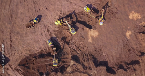 Aerial: Vast excavation site with multiple heavy industry vehicles.