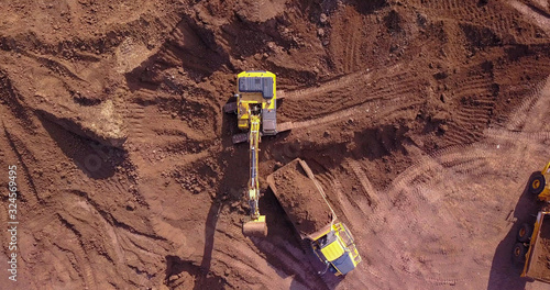 Excavators loading soil onto an Articulated hauler Trucks. Aerial image.