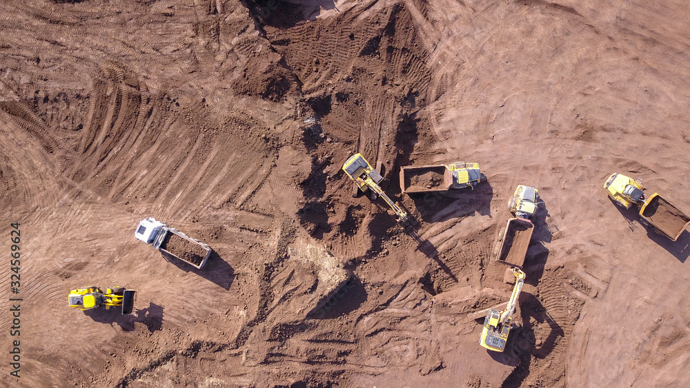 Earthmoving equipment. Aerial view of large construction site with several earthmover machines. Earthmoving equipment. Aerial view of large construction site with several earthmover machines.