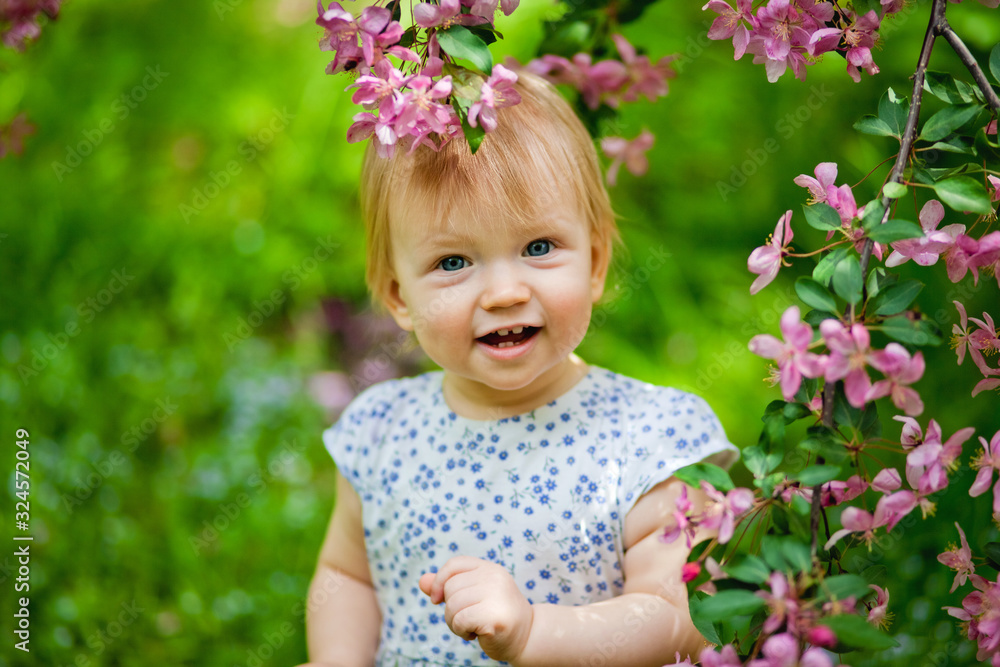 cute girl in the Park near a cherry blossom branch cute girl in the Park near a cherry blossom branch