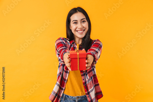 Photo of happy young woman smiling and holding gift box