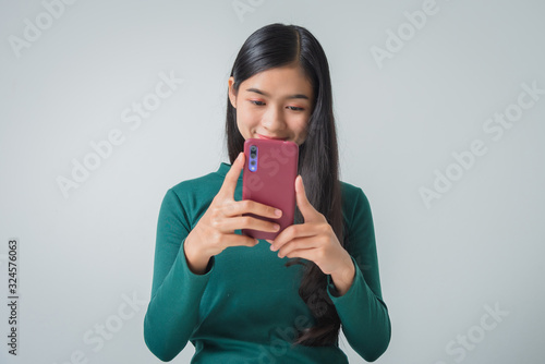 Shot of pretty young female holds modern smart phone amazed by unbelievable message winner, happy feeling.