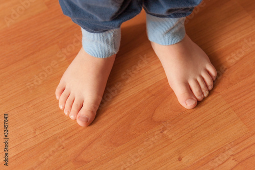 Close up of little bare feet of a standing three year old boy