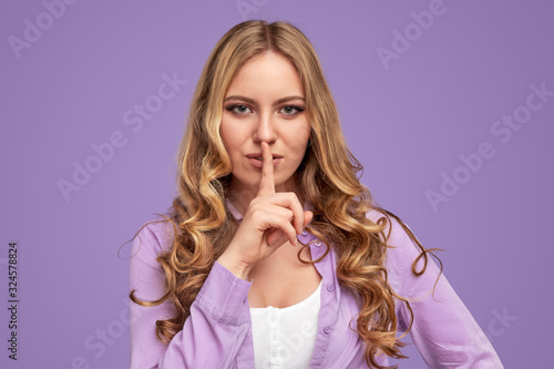 Stylish woman in trendy outfit showing shh sign