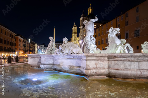 The Fountain of Neptune in Piazza Navona in Rome, Italy. Night view of the sculptural group and the splendid pool. Nereids with putti and sea horses and Neptune fighting an octopus.