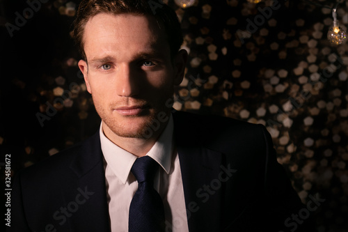 Foto Good looking man in suit with blue eyes and beard looking at camera with bokeh i