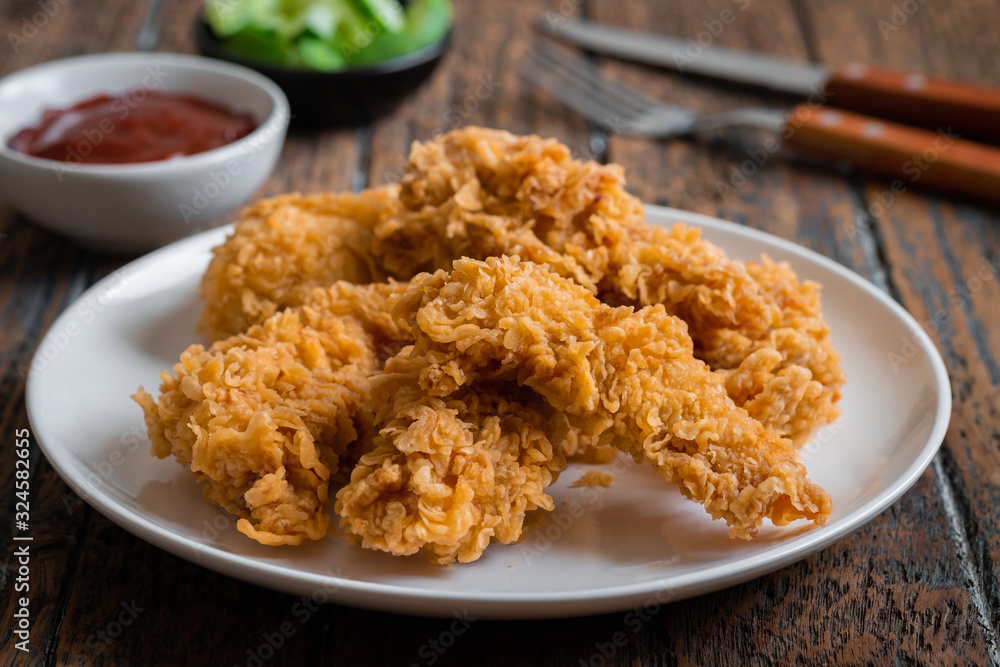 Crispy fried breaded chicken strips on plate and ketchup Crispy fried breaded chicken strips on plate and ketchup
