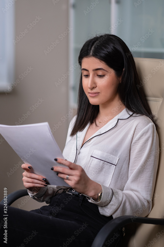 Portrait of a young beautiful woman, an office employee in a white shirt. A woman works at a computer. Portrait of a young beautiful woman, an office employee in a white shirt. A woman works at a computer.