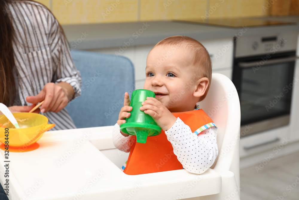 Young mother feeding her little baby at home Young mother feeding her little baby at home