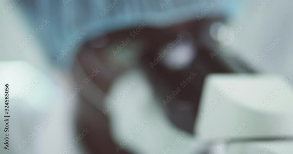 Man working in laboratory looks into a microscope. Close-up Man working in laboratory looks into a microscope. Close-up