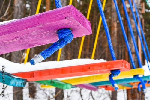 Multi-colored wooden steps in a rope park photo