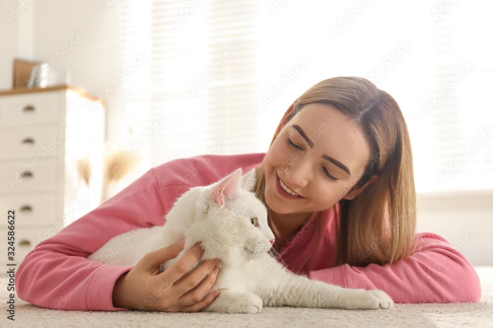 Young woman with her beautiful white cat at home. Fluffy pet Young woman with her beautiful white cat at home. Fluffy pet