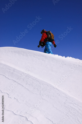 A man with a camera and a backpack on the snowy slope