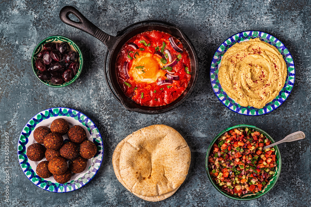 Falafel, hummus, shakshuka, Israeli salad - traditional dishes of Israeli cuisine. Falafel, hummus, shakshuka, Israeli salad - traditional dishes of Israeli cuisine.
