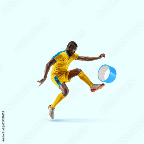 Soccer player kicking duct tape like a ball on blue background. Copyspace for your proposal. Modern design. Contemporary artwork, collage. Concept of sport, office, work, dreams, business, action. © master1305