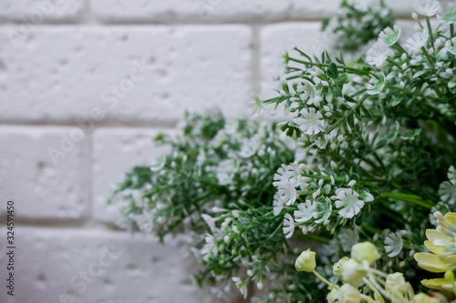 Artificial flower arrangement in flower shop with brick wall. . © reddish