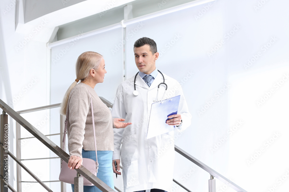 Doctor and patient discussing diagnosis on stairs in hospital Doctor and patient discussing diagnosis on stairs in hospital