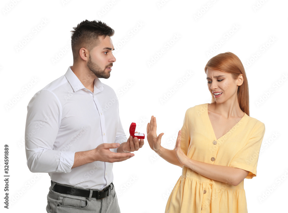 Young woman rejecting engagement ring from boyfriend on white background Young woman rejecting engagement ring from boyfriend on white background