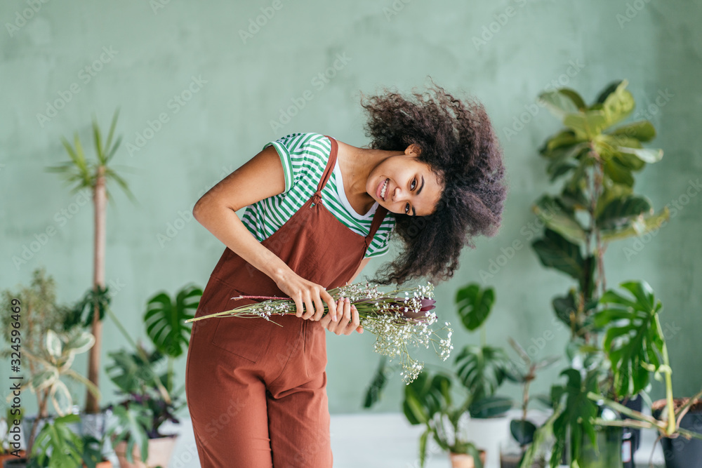 Young woman cultivating home plants Young woman cultivating home plants