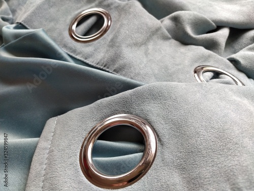 Foto two metal eyelets on gray-blue velvet curtains