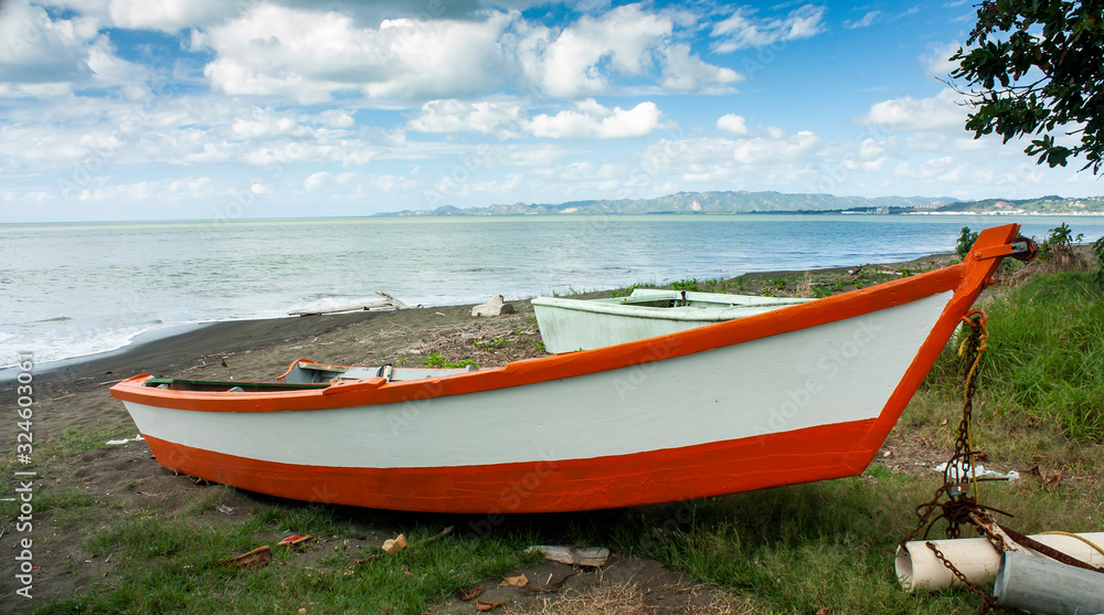 Puerto Rico Rustic red and white wooden fishing boat on the coast against a beautiful sky Puerto Rico Rustic red and white wooden fishing boat on the coast against a beautiful sky