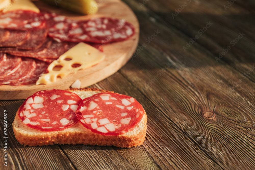 Sausage sandwich and sausage sliced on a wooden board. Sausage sandwich and sausage sliced on a wooden board.
