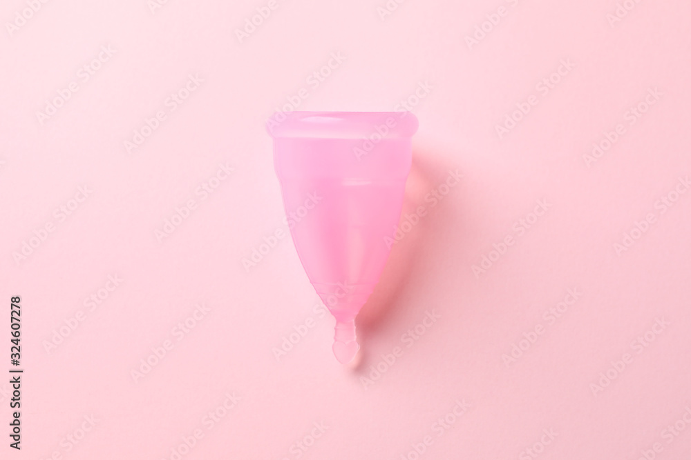Menstrual cup on pink background, close up and space for text
