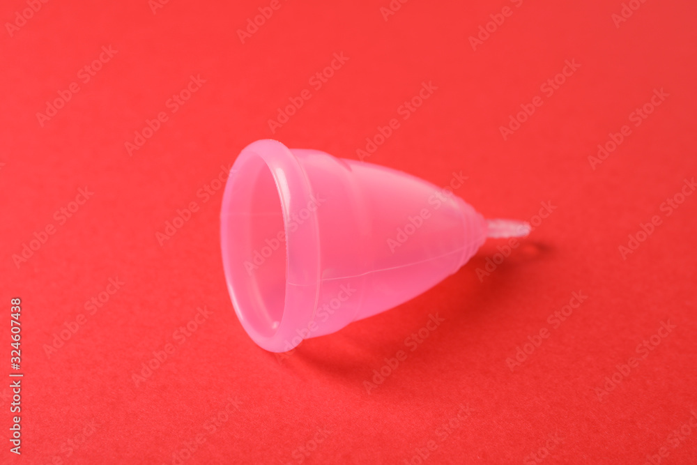 Menstrual cup on red background, close up