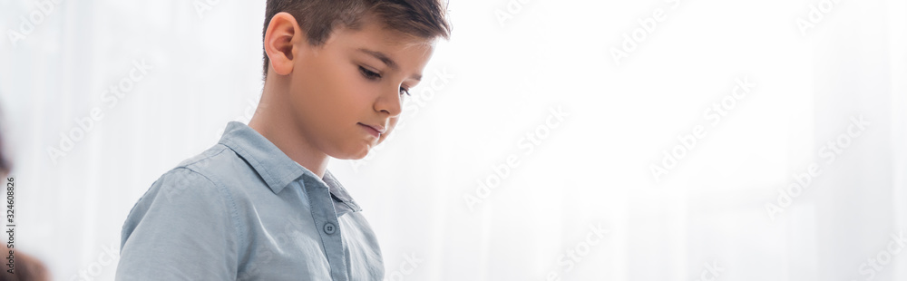 panoramic shot of upset schoolboy in classroom panoramic shot of upset schoolboy in classroom