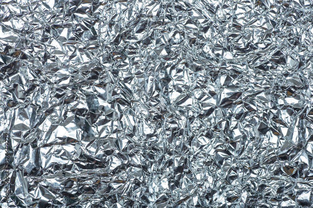 Crumpled foil background. The texture of crumpled iron aluminum foil reflective color. Copy space Crumpled foil background. The texture of crumpled iron aluminum foil reflective color. Copy space