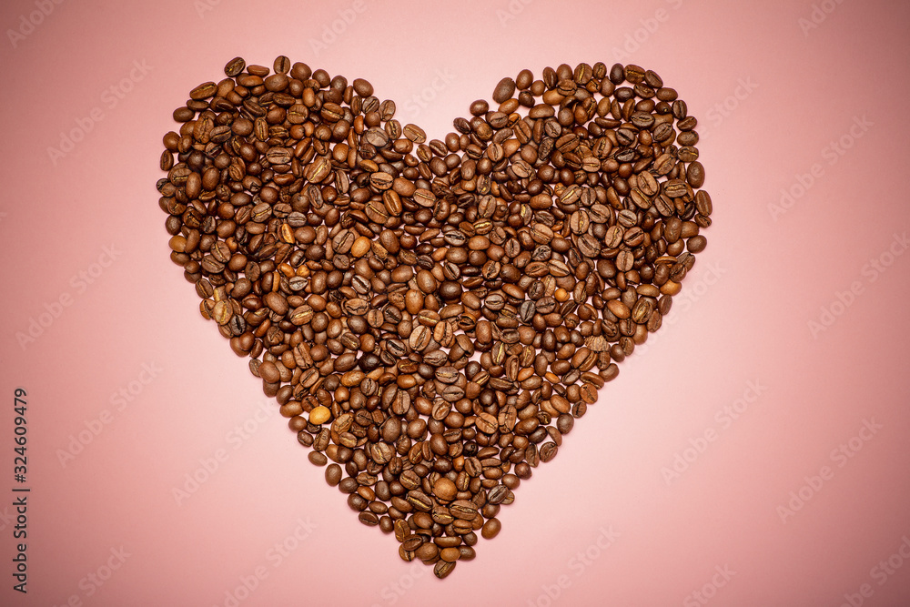 Heart shaped coffee beans on a pink background. Love for coffee concept