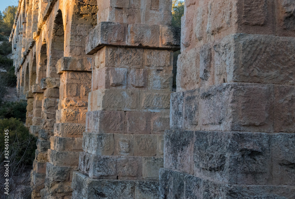 roman aqueduct tarragona.Roman aqueduct with arches at sunset.Close up of aqueduct