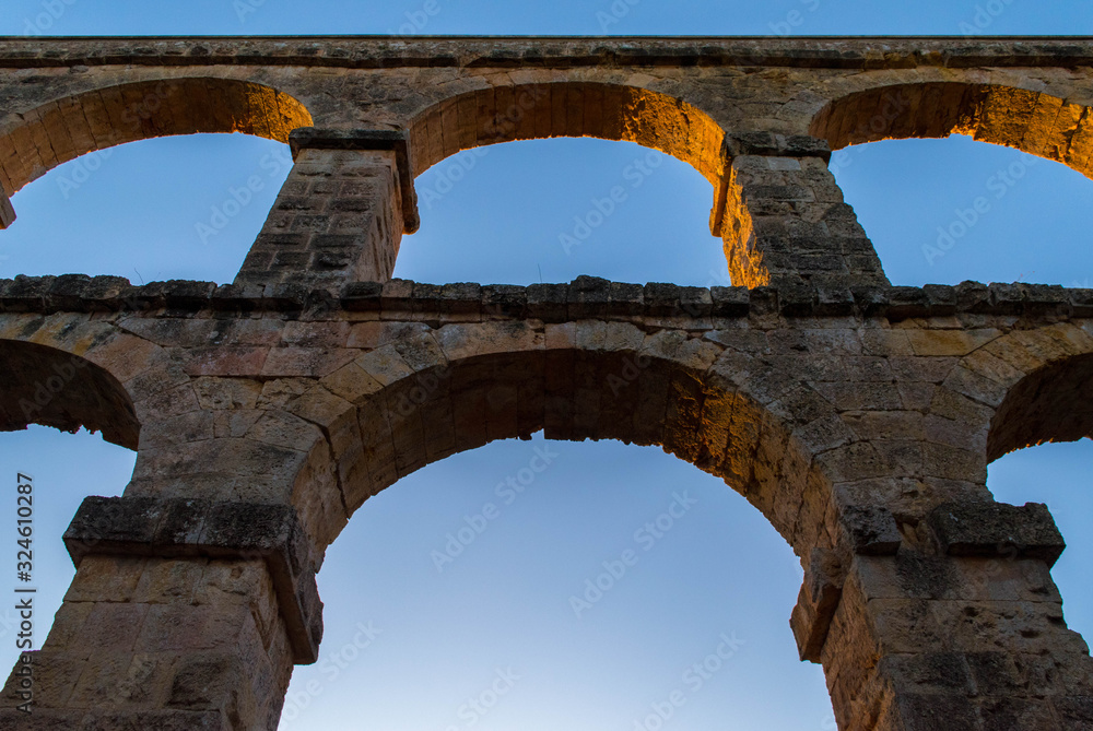 roman aqueduct tarragona.Roman aqueduct with arches at sunset.Close up of aqueduct