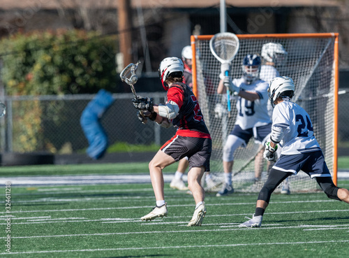 Young athletes making amazing plays while playing in a Lacrosse game photo