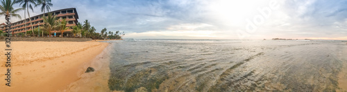 Beautiful panoramic landscape of sunset over the ocean and tropical hotel resort