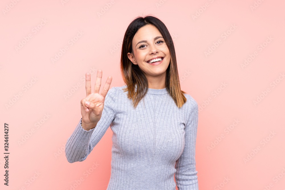 Woman over isolated pink background happy and counting three with fingers Woman over isolated pink background happy and counting three with fingers