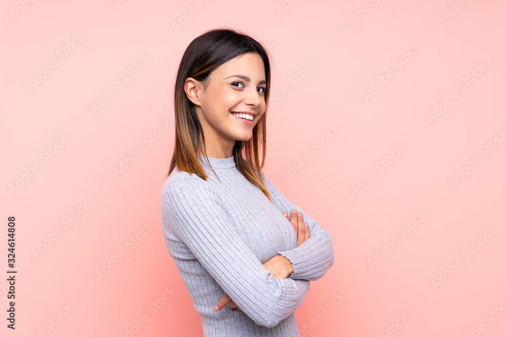 Fototapeta premium Woman over isolated pink background with arms crossed and looking forward