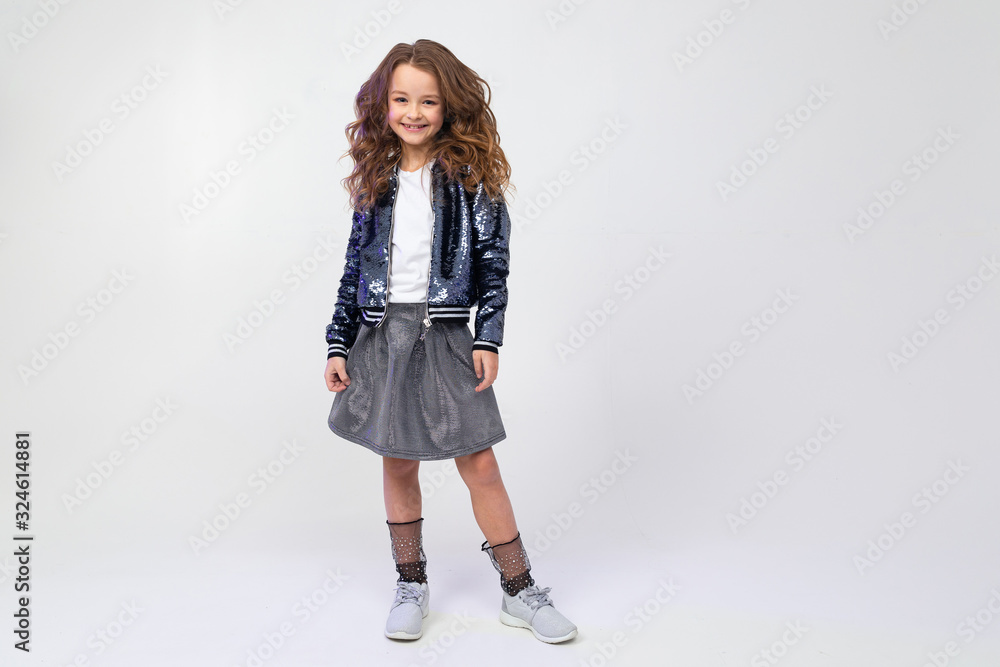 Stylish attractive girl in a beautiful image posing in full growth on a light studio background