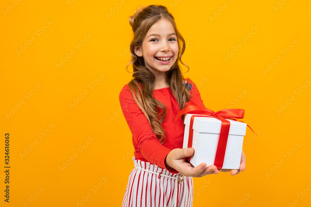 smiling beautiful girl holds out a box with a birthday present on a yellow background smiling beautiful girl holds out a box with a birthday present on a yellow background
