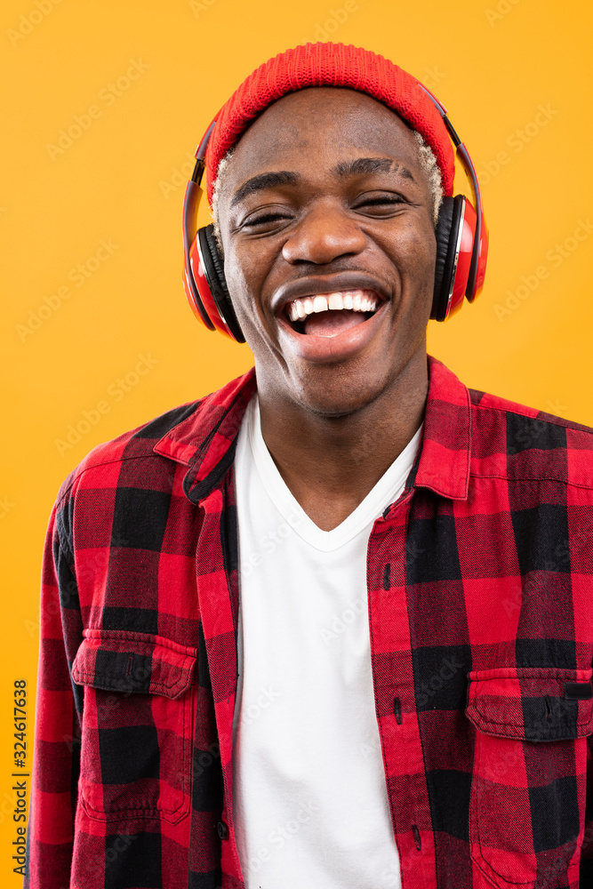 Fototapeta premium handsome smiling black american man listening to music using headphones